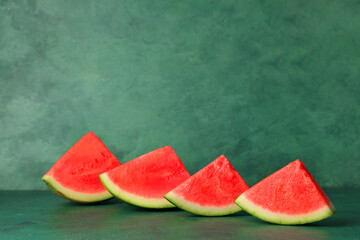 Pieces of sweet watermelon on green background