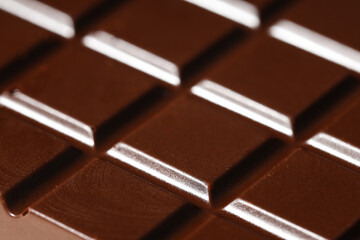 Tasty dark chocolate bar as background, closeup