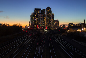 Fototapeta premium Downtown city at night. Sunset in financial district. railway interchange, condos, office buildings illuminated. skyline Toronto, Ontario, Canada