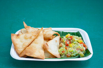 Fresh guacamole with crispy tortilla chips on eco-friendly plate.