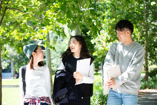 笑いながら話をしている大学生3人