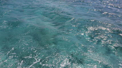 Turquoise blue green water of the sea ocean with waves that ripple across the surface of clear, turquoise water, showcasing the pristine beauty and dynamic motion of the open sea