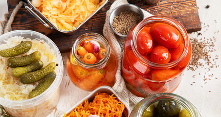 Fermented products on a wooden background. Pickled vegetables in jars