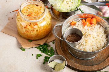 Winter salad of marinated cabbage and carrot Homemade sauerkraut in a jar on wooden background