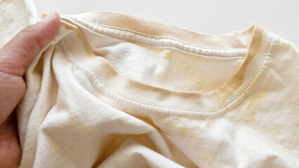 Dirty clothes with yellow stain on it. The concept of how to remove deep stains from clothes or...