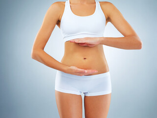 Woman, underwear and hands by stomach in studio for weight loss, progress and healthy body. Self...