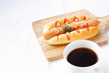 おいしそうなフランクフルトソーセージパン（ホットドッグ）とコーヒーでランチタイム

