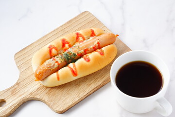 おいしそうなフランクフルトソーセージパン（ホットドッグ）とコーヒーでランチタイム
