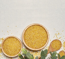 top view flat lay pile of bulgur or burghul wheat on table white background in wood bowl with copy space