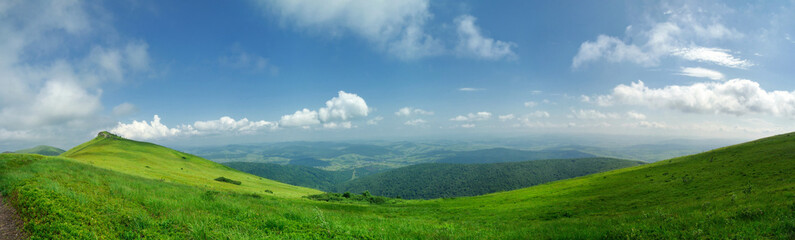 Naklejka premium Panorama of green hills on a sunny, summer day