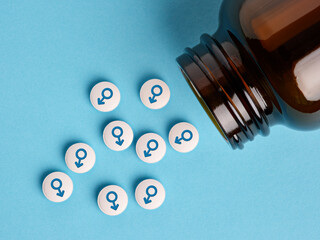 Medical hormone pills with male symbol spilling out of the bottle.