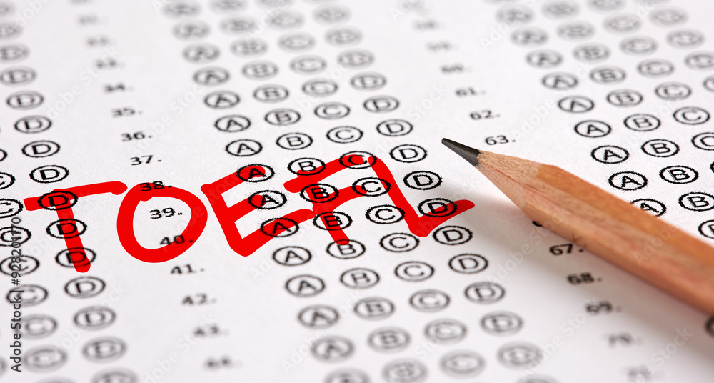 Wall mural close up view of an exam paper with the word toefl test of english as a foreign language and a penci