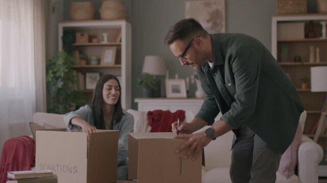 Happy young couple unpacking or packing boxes and moving into a new home