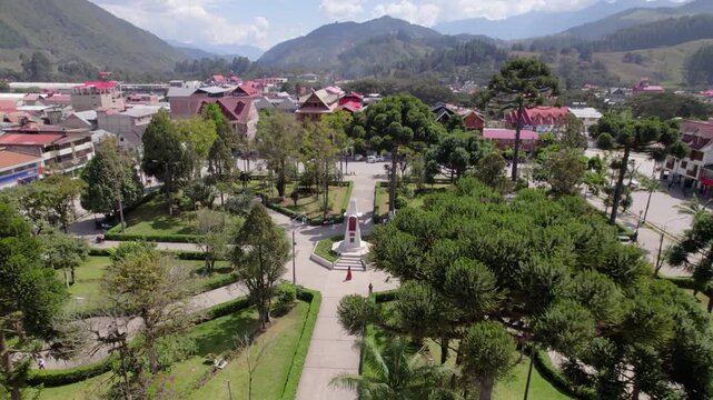 A reveal shot from a drone of the Plaza de Armas with tourists and residents in Oxapampa, Peru.