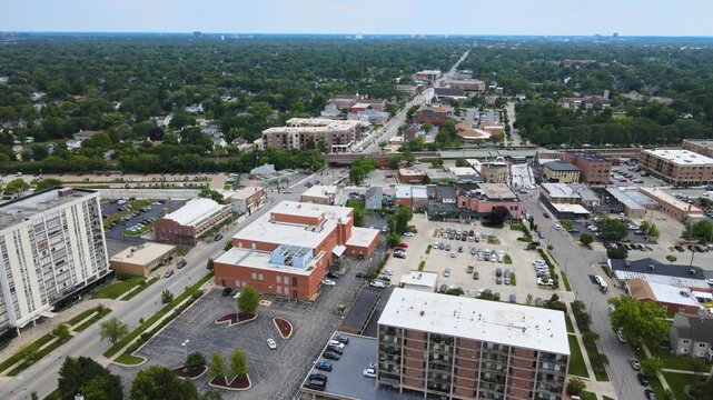 Drone shot of Lombard, Illinois, capturing suburban streets, train tracks, and mixed residential and commercial buildings. Orbit Left Cloudy Day S