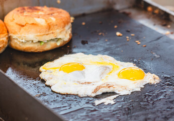 Eggs are fried in oil on a metal plate