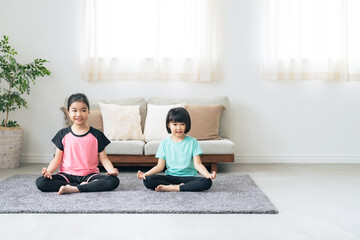 部屋でヨガをする二人の女の子