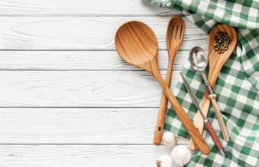 Wooden background with a green checkered tablecloth and kitchen utensils. A concept for cooking.