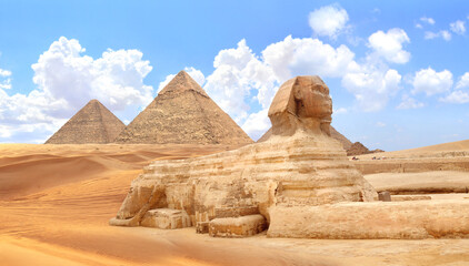Famous Great Sphinx and pyramids of Chephren and Cheops, Cairo, Egypt. Great Pyramids and ancient statue of Sphinx, mythical creature with head of man and body of lion, Giza complex (Giza Necropolis)