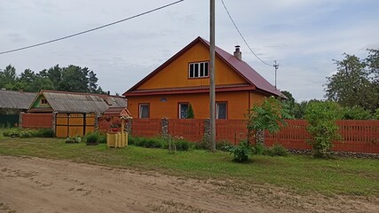 Russian wooden house with a fence on the street in the village