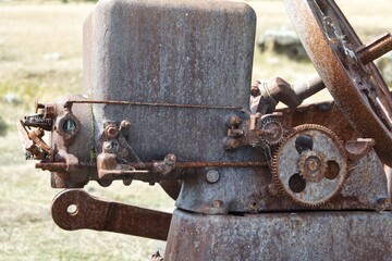 Rusty remains of an agriculture vehicle. Old rusty metal structure. Interesting textures of rusty metal. An ancient piece of farming and agriculture technology. 