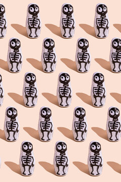 Pattern of rows of Halloween candy with skeleton wrapping against beige background