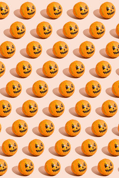 Pattern of rows of Halloween candy with jack o lantern wrapping against beige background