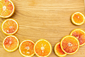 Blood Sicilian fresh oranges on wooden cutting board. Sliced ripe juicy citrus fruits. Top...