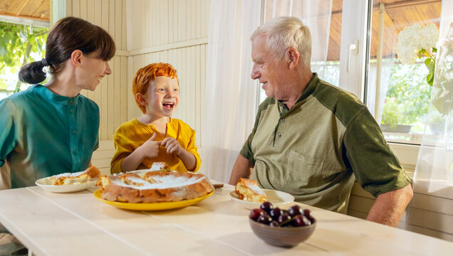 Cute boy spending leisure time with mother and grandfather at home