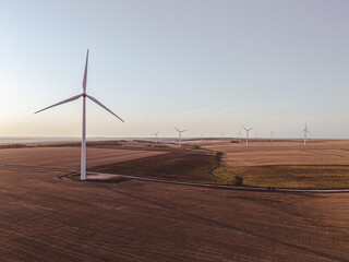  zero carbon footprint and alternative power source. wind turbine in field generating renewable energy at sunset
