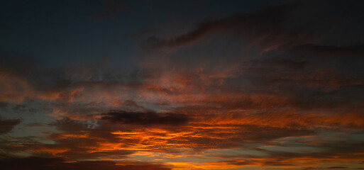Tropical sunset. Beautiful sunset sky with clouds. Sky blue and orange light of the sun through the clouds in sky. Background of dark clouds before storm. Dramatic clouds. Apocalyptic sky, dark cloud.