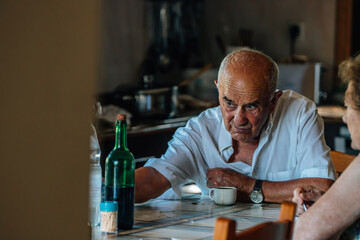 Family life of a senior couple at home drinking coffee