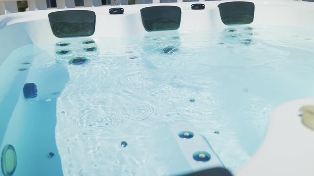 Close-up shot bubbling water in hot tub with headrests. Blue water in jacuzzi