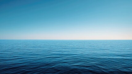 Obraz premium A panoramic shot of a blue sea with a distant horizon and a cloudless sky.