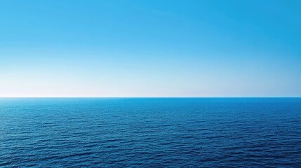 Obraz premium A panoramic shot of a blue sea with a distant horizon and a cloudless sky.