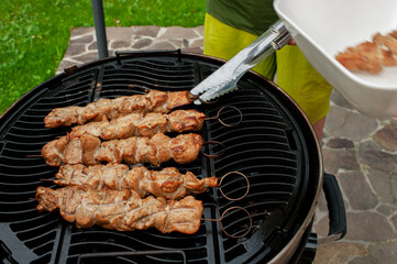 Fried meat strung on skewers is fried over an open fire on a grill.