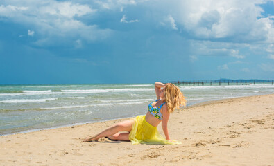 Vacation at sea, woman at Italy beach. Lady in bright swimwear