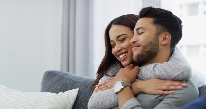 Home, hug and couple with love, relax and happiness with marriage, commitment and bonding together. Romance, woman and man on a couch, resting and relationship with joy, smile and romantic with break