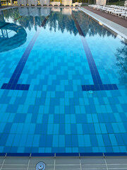 Obraz premium Handrail stairs to the blue pool.Pool with stairs and water. Stainless steel stairs to the pool.