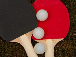 Table tennis bats and balls on grass