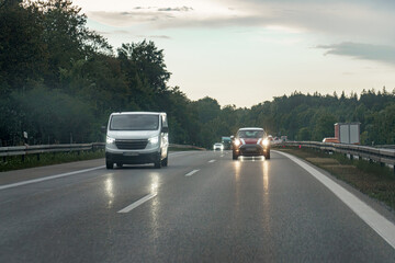 Cars with low beams on on the motorway in the evening.