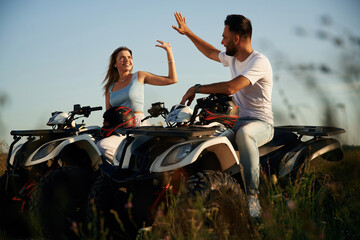 Rest time, sitting and taking a break. Man and woman are on ATV outdoors