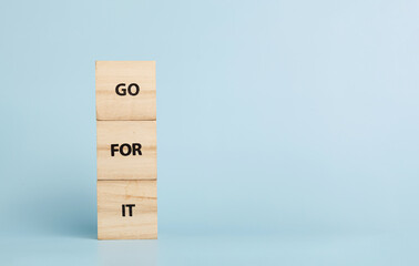 Wooden cubes with inscriptions Go For It on a blue background