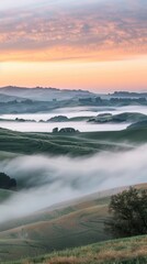 Obraz premium The soft twilight descends on rolling hills veiled in fog, painting a peaceful scene in hues of blue and orange.