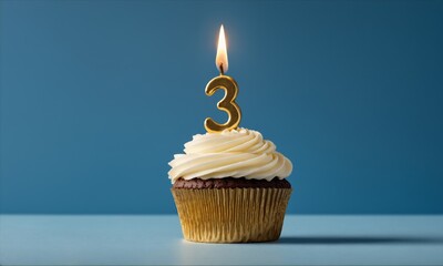 Chocolate cupcake with vanilla frosting and a lit golden number three candle