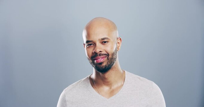 Face, smile or bald man laughing at joke or crazy comedy in studio isolated on gray background. Funny, biracial model or happy male person with freedom, pride or beard to relax alone with humor