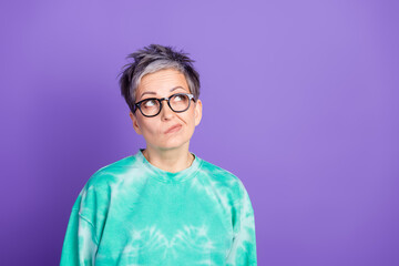 Photo portrait of lovely pensioner lady look skeptical empty space dressed stylish green garment...
