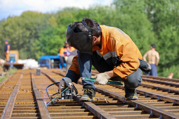 Welder working in the city. Construction worker on steel beams, welding works