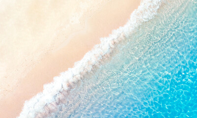 Tropical Beach with the soft wave water of the sea on the sandy beach background as texture with splashes and bubbles