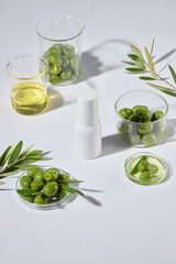 White table top featuring several lab glassware above with an unbranded cosmetic bottle in center. Photo was taken from high angle, blank space for designing